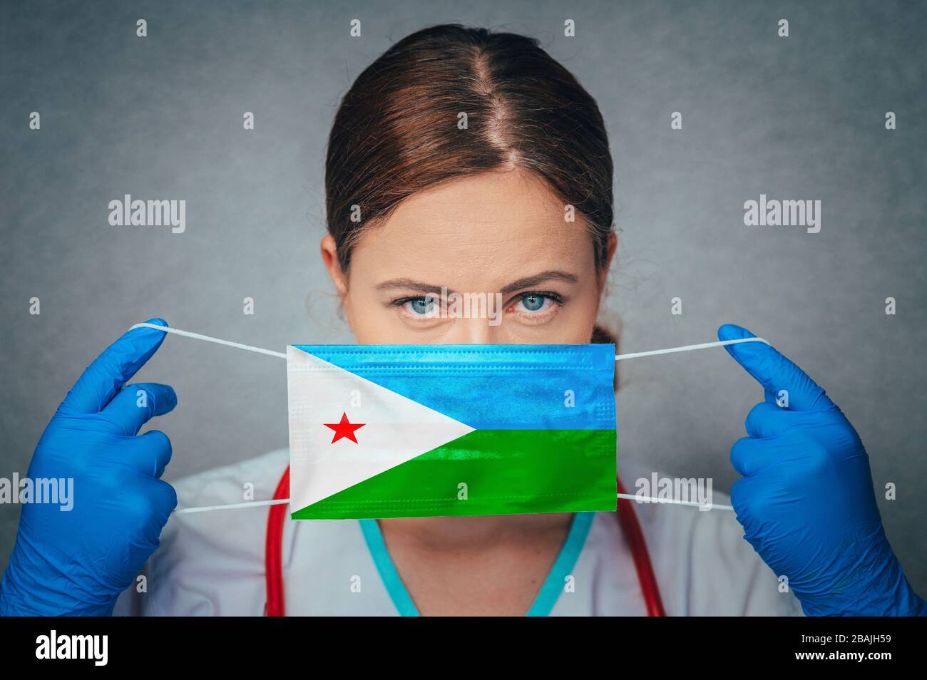 Coronavirus in Djibouti Female Doctor Portrait hold protect Face surgical medical mask with Djibouti National Flag. Illness, Virus Covid-19 in Djibout Stock Photo