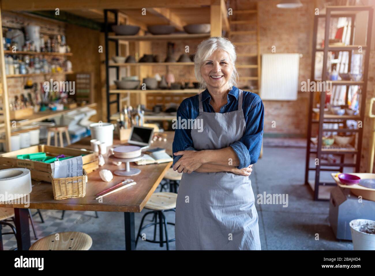 Portrait of senior female pottery artist in her art studio Stock Photo