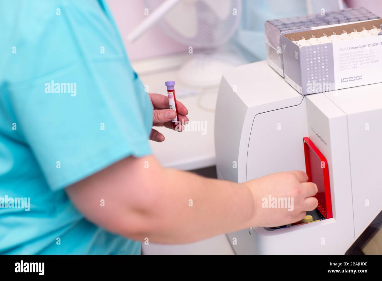 Patient Lab Aid Blood analyzer. Laboratory assistant in medical laboratory holds test ...