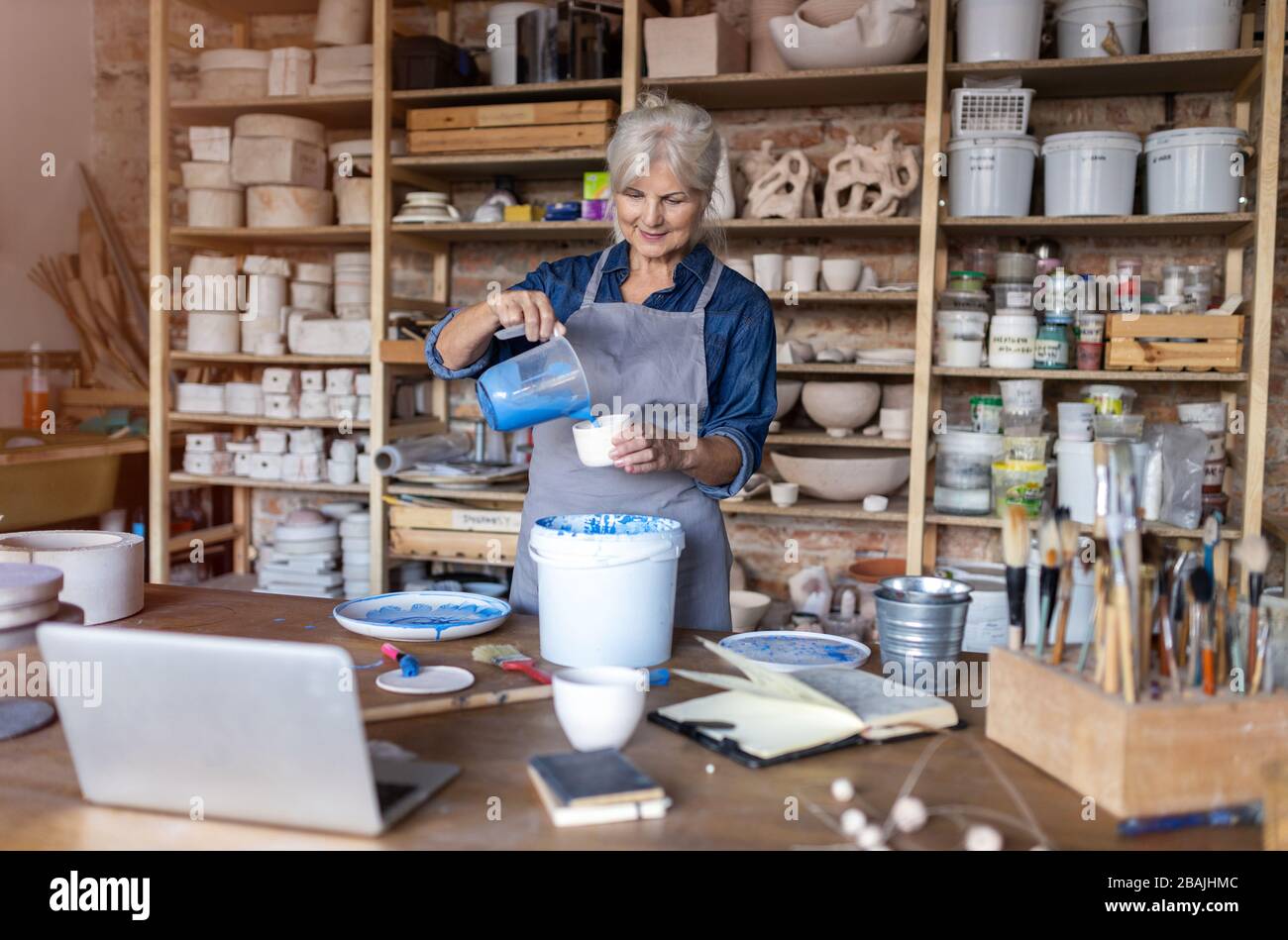 Portrait of senior female pottery artist in her art studio Stock Photo