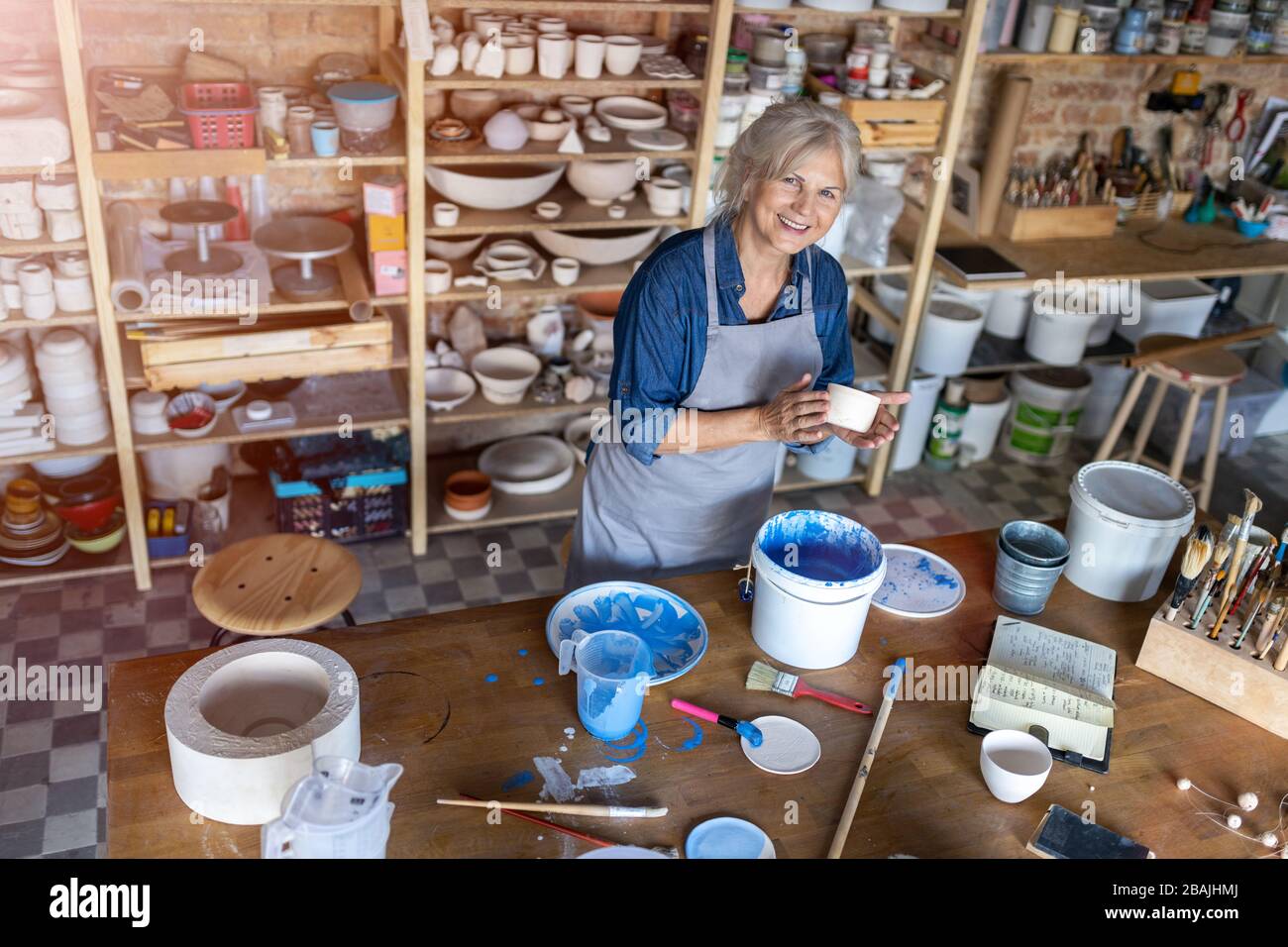 Portrait of senior female pottery artist in her art studio Stock Photo ...