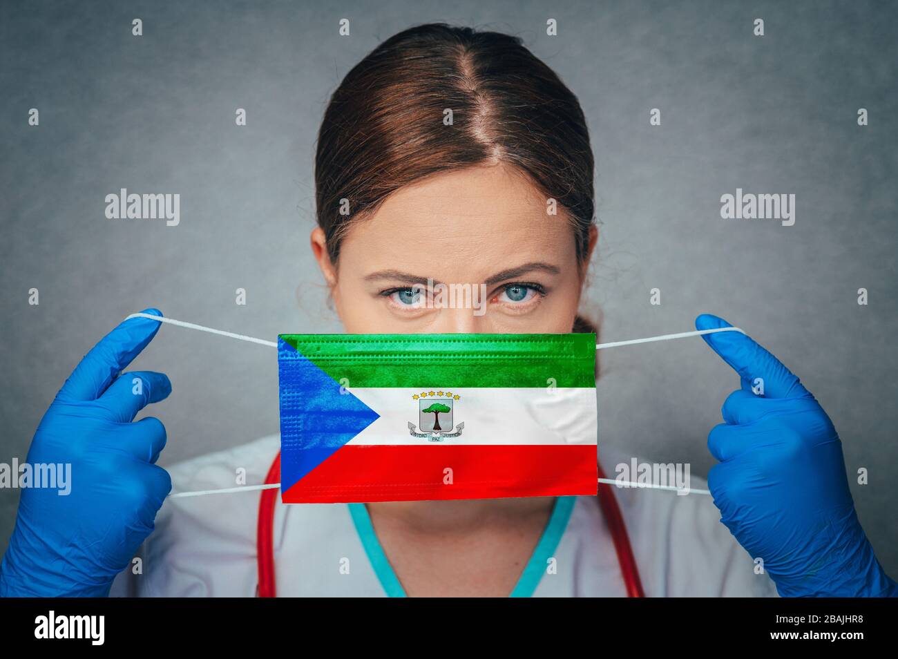 Coronavirus in Equatorial Guinea Female Doctor Portrait hold protect Face surgical medical mask with Equatorial Guinea National Flag. Illness, Virus C Stock Photo