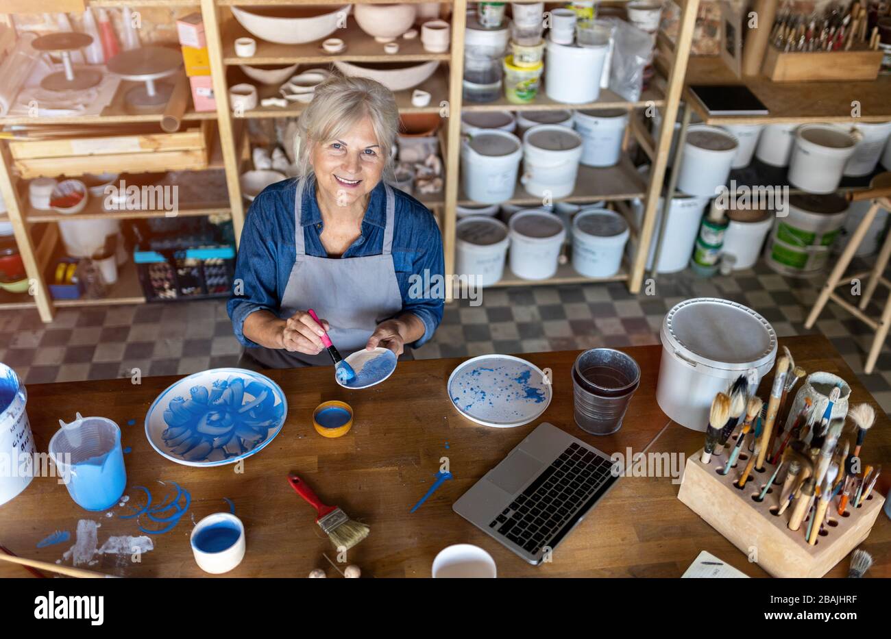 Portrait of senior female pottery artist in her art studio Stock Photo