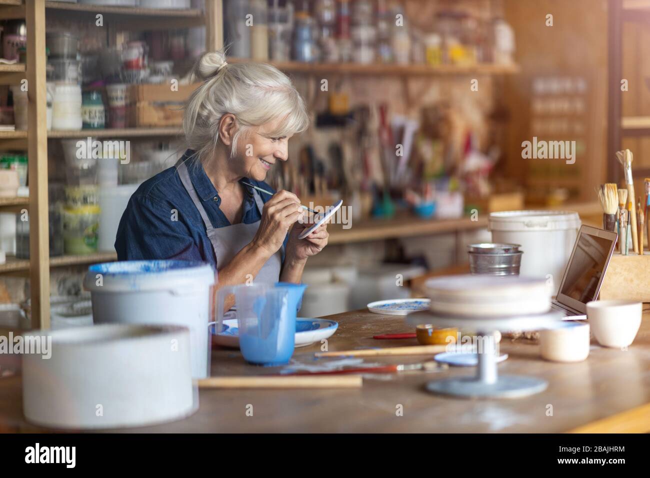 Portrait of senior female pottery artist in her art studio Stock Photo