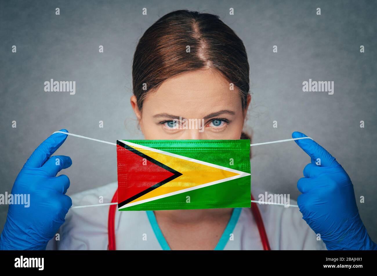 Coronavirus in Guyana Female Doctor Portrait hold protect Face surgical medical mask with Guyana National Flag. Illness, Virus Covid-19 in Guyana, con Stock Photo