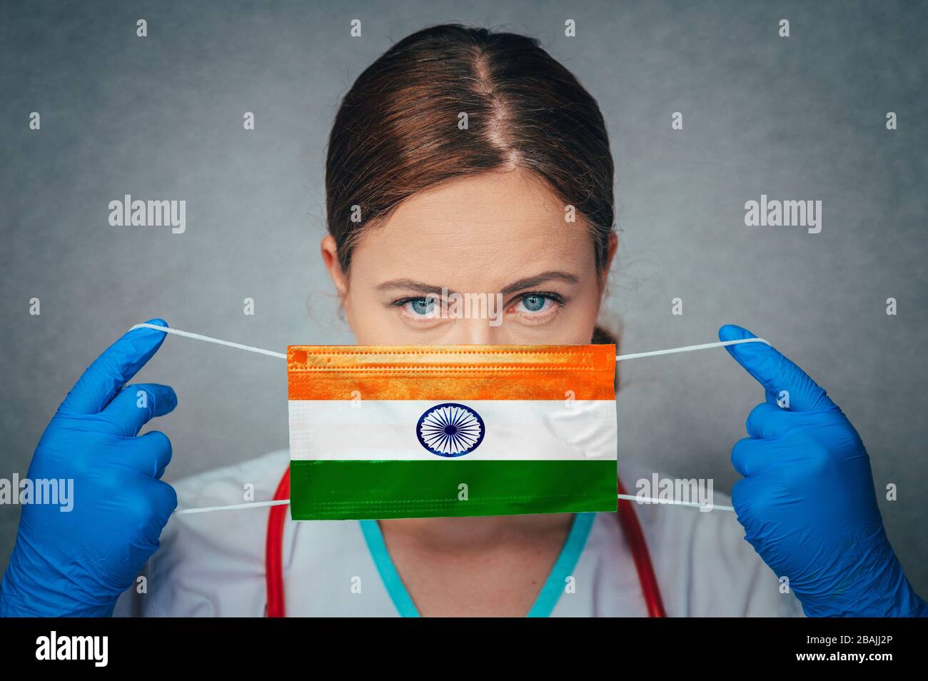 Coronavirus in India Female Doctor Portrait hold protect Face surgical medical mask with India National Flag. Illness, Virus Covid-19 in India, concep Stock Photo