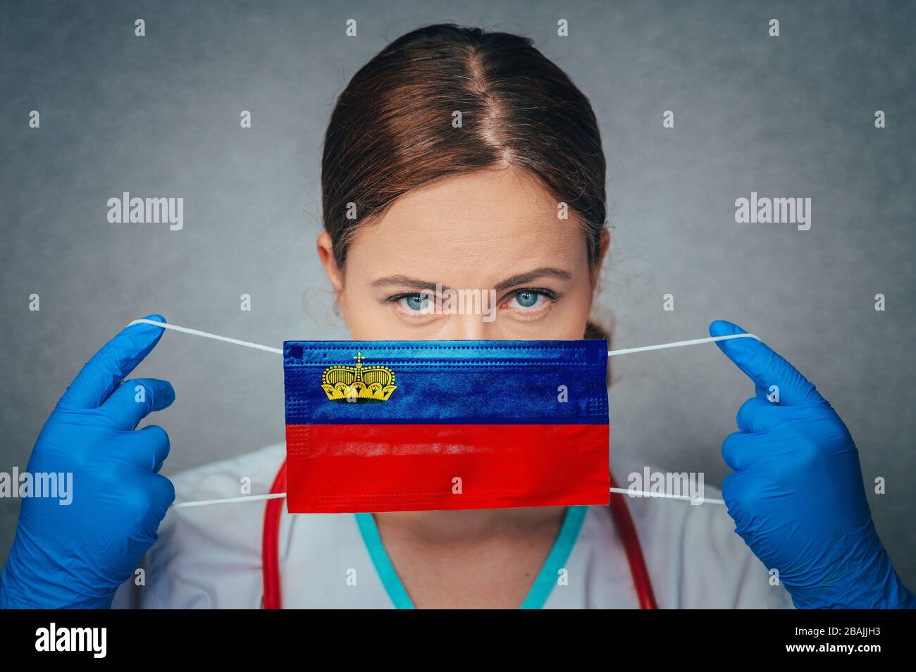 Coronavirus in Liechtenstein Female Doctor Portrait hold protect Face surgical medical mask with Liechtenstein National Flag. Illness, Virus Covid-19 Stock Photo