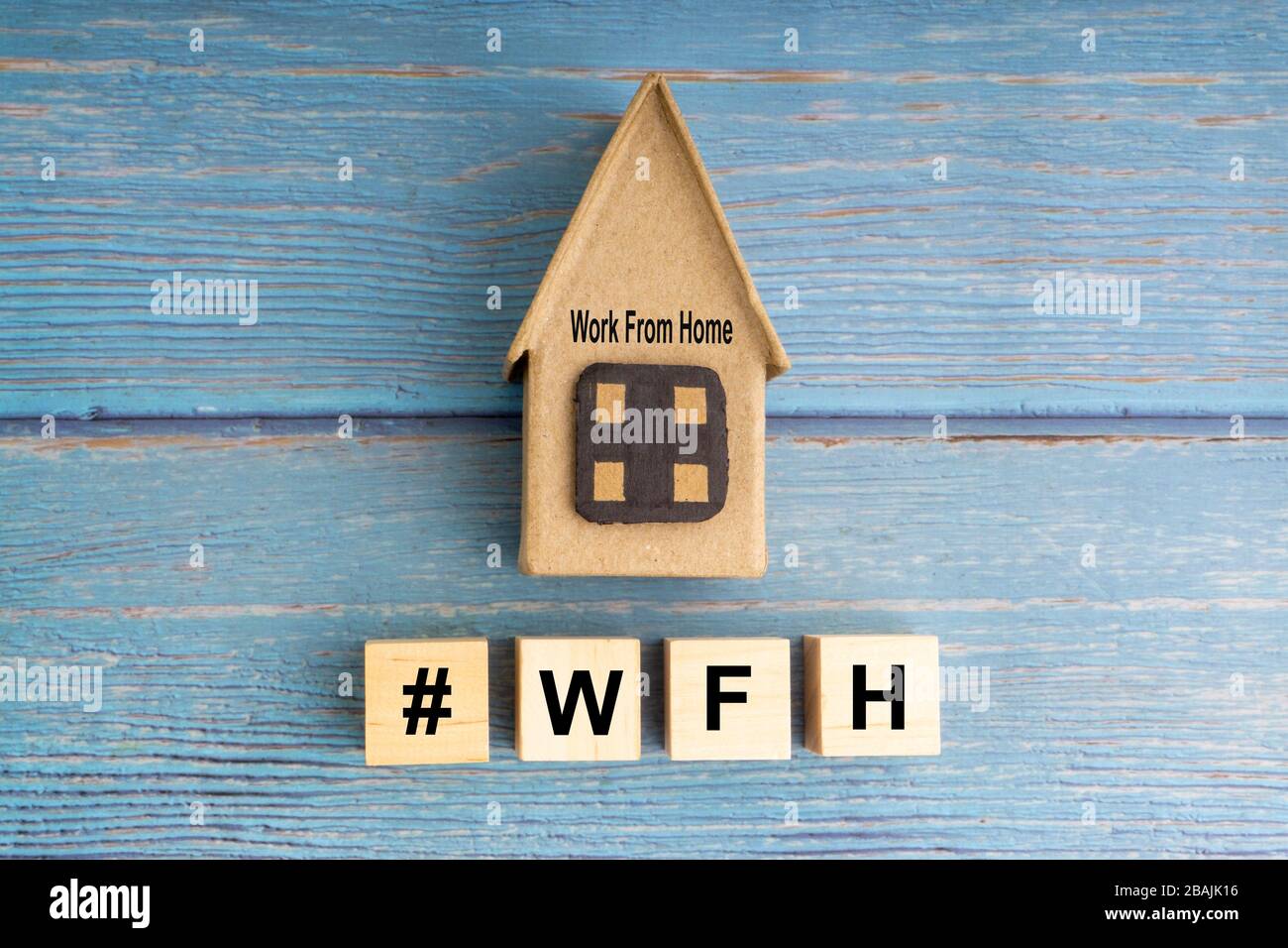 Concept image a wooden block and word - #WFH ( WORK FROM HOME ) on wooden background Stock Photo