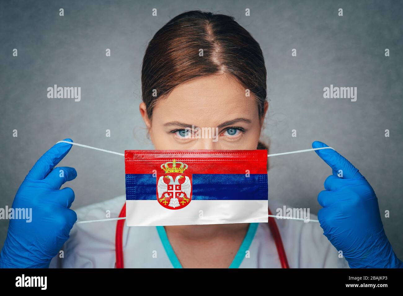 Coronavirus in Serbia Female Doctor Portrait hold protect Face surgical medical mask with Serbia National Flag. Illness, Virus Covid-19 in Serbia, con Stock Photo