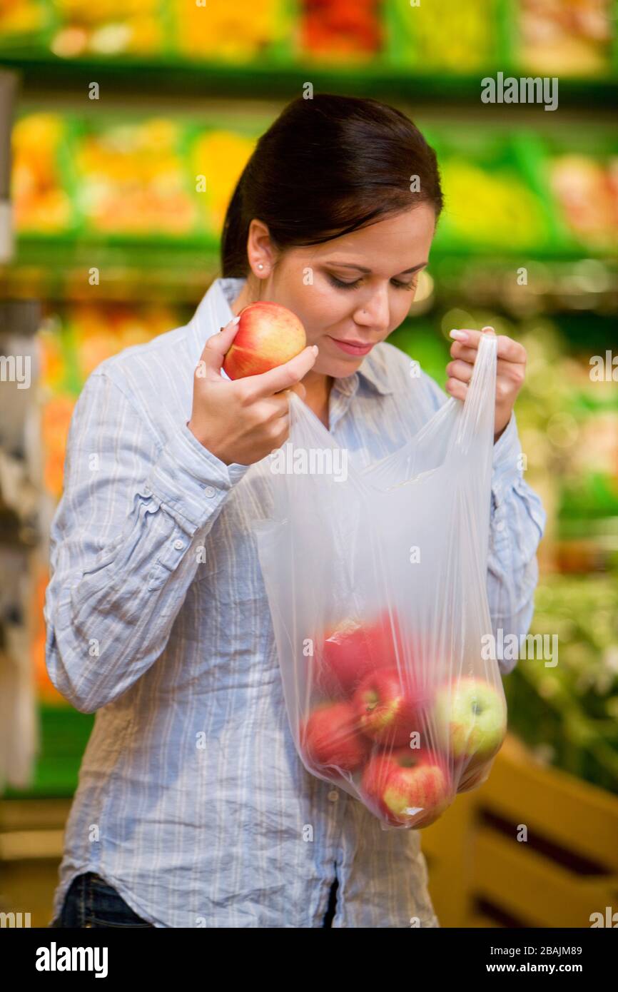 Junge Frau kauft im Supermarkt Lebensmittel und Obst ein, MR: Yes Stock Photo