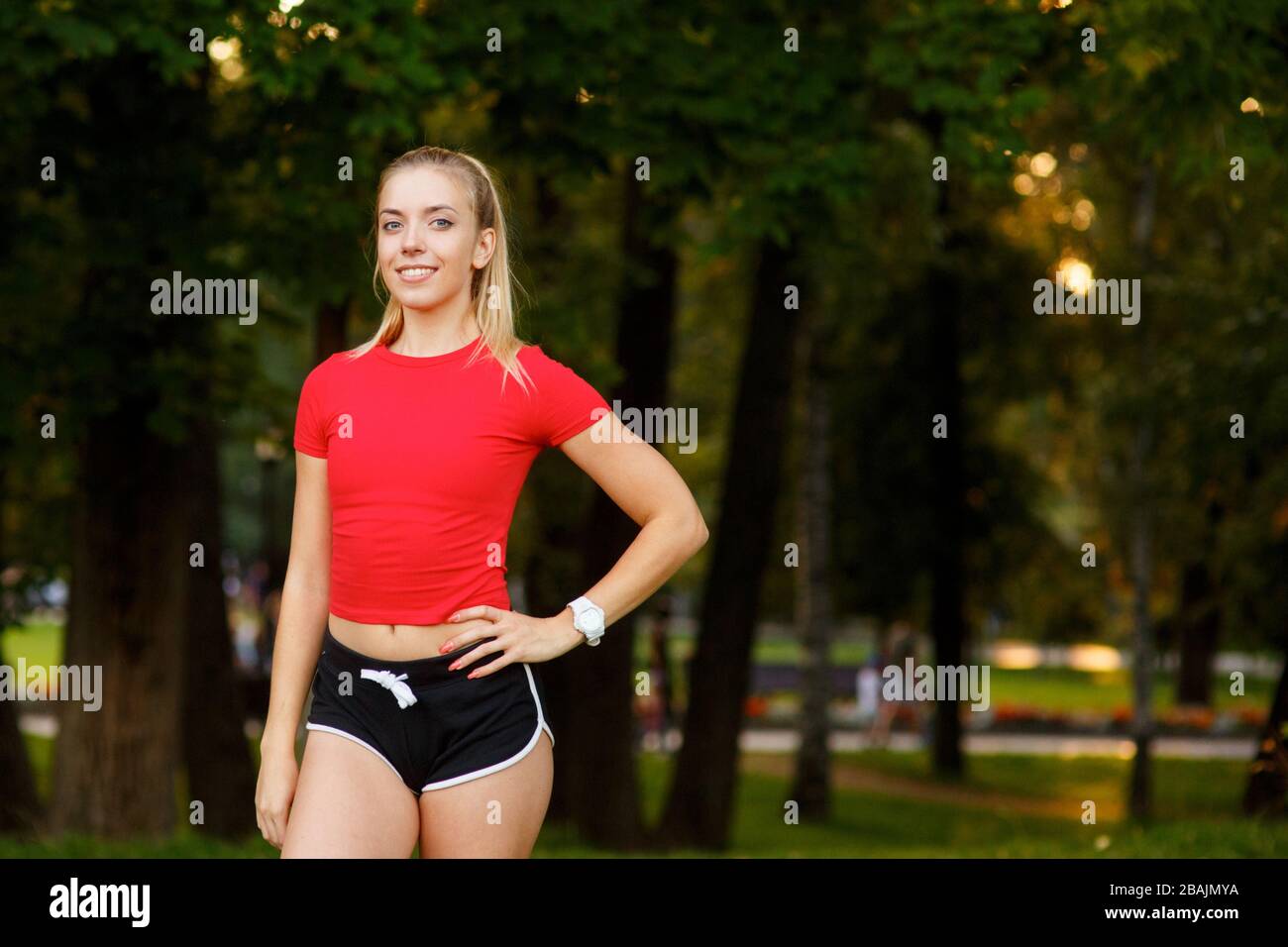 Fit pretty black girl in sports bra and shorts stretching in a wooded area  or forest Stock Photo - Alamy