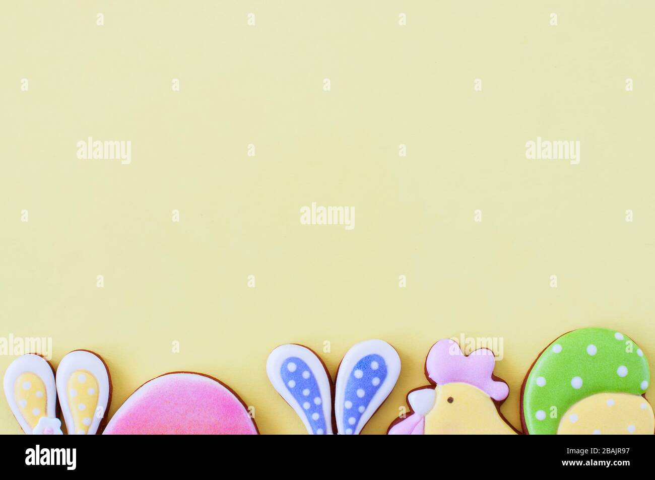 Easter background concept. Colored easter cookies on yellow background. Top view. Stock Photo