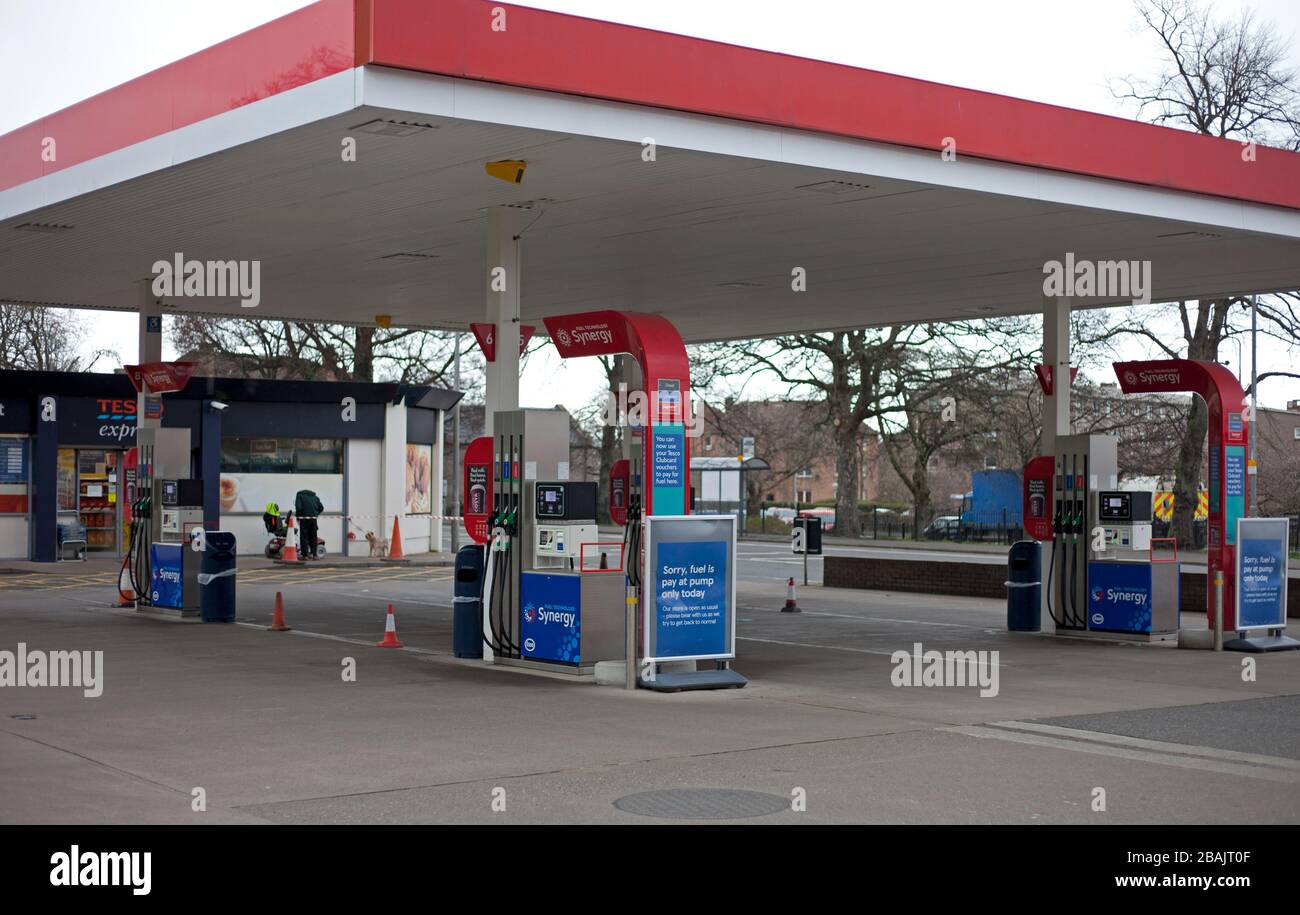 Edinburgh, Scotland, UK. 28th Mar 2020. Coronavirus effect, at 11am Saturday, deserted streets and Willowbrae Road Esso fuel station without any cars or vehicles on the forecourt. With display  signs informing customers that only pay at the pump is acceptable, to prevent their staff from unecessary contact, although their convenience store is still open, operating a social distancing queue system. Credit: Arch White/Alamy Live News Stock Photo