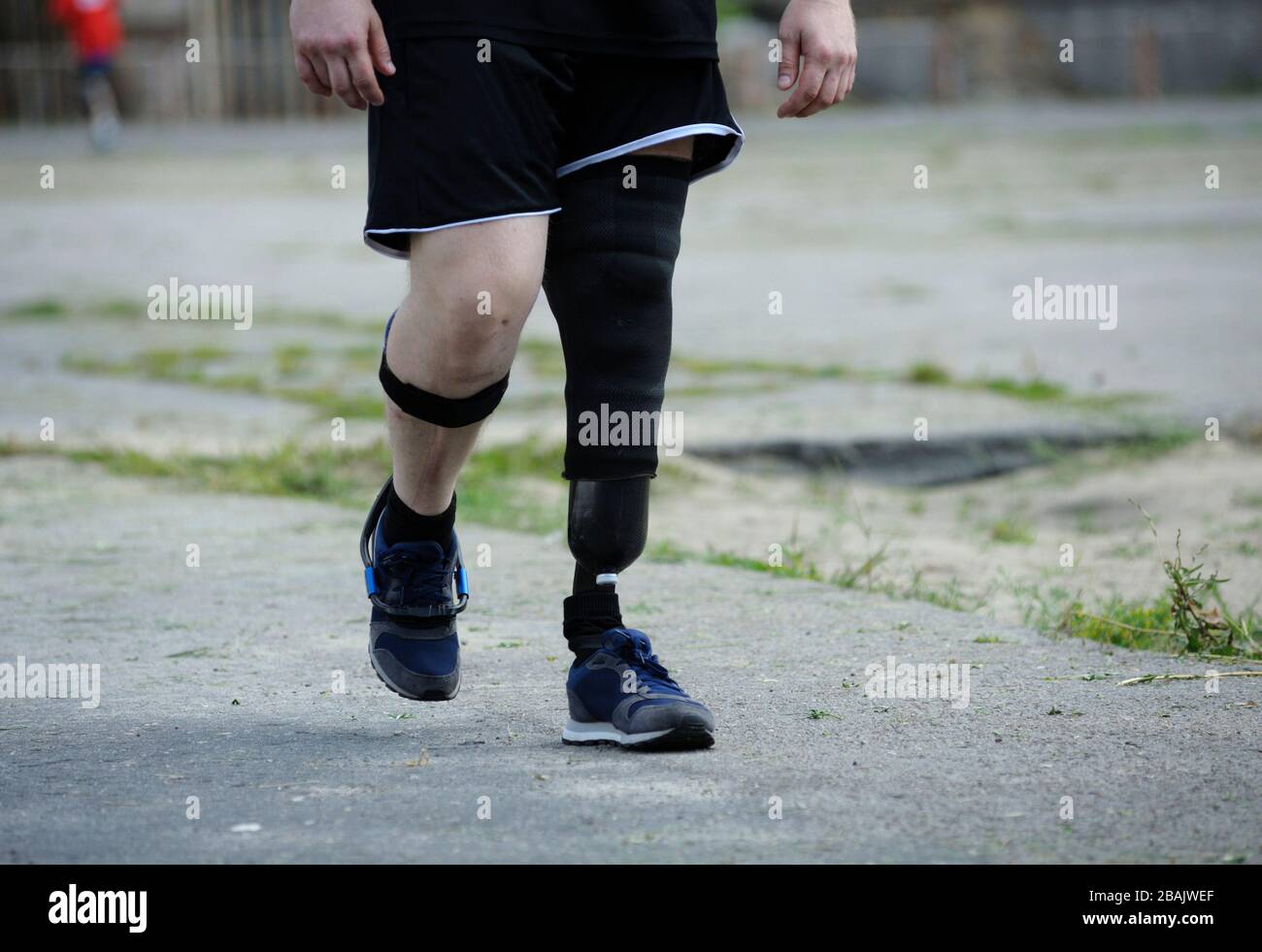 Disabled runner with an artificial leg walking on stadium Stock Photo