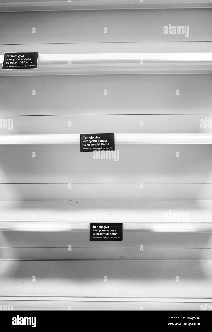 empty shelf in a shop with a sign saying this product is limited 5 to a customer do to panic buying Stock Photo