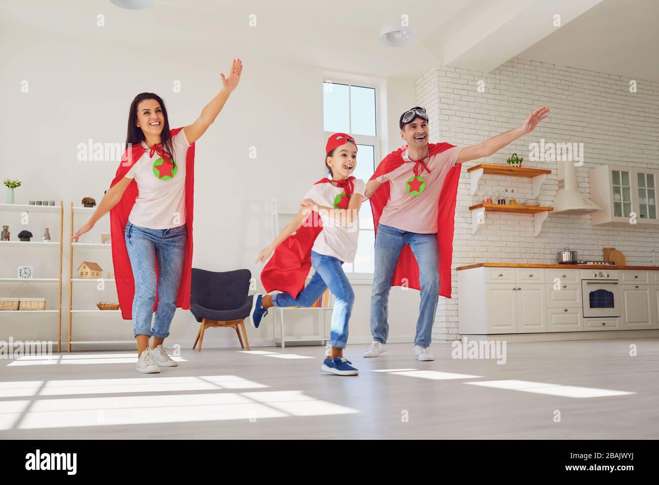 Happy family in super hero costumes.Funny family play fun in the room. Stock Photo