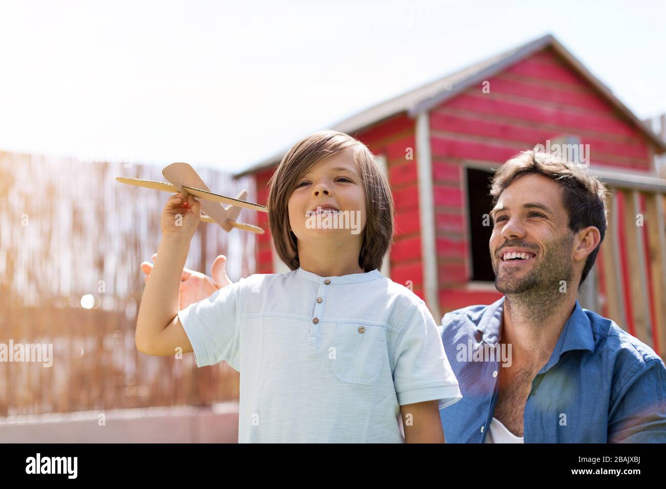 Father and son playing with a paper toy airplane together Stock Photo