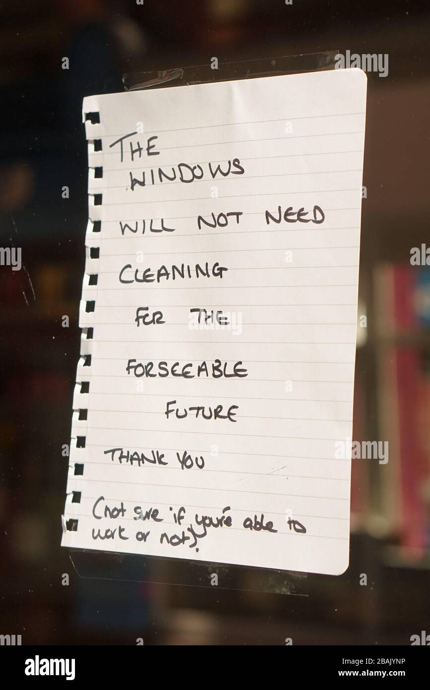 A handwritten note to the window cleaner in a shop window due to corona-virus government lock-down advice Stock Photo