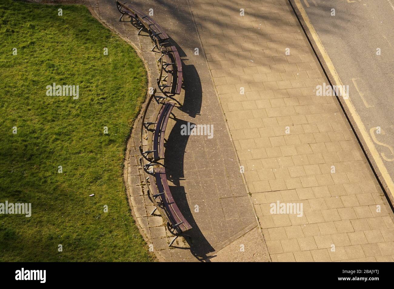 A curved row of empty benches from above Stock Photo