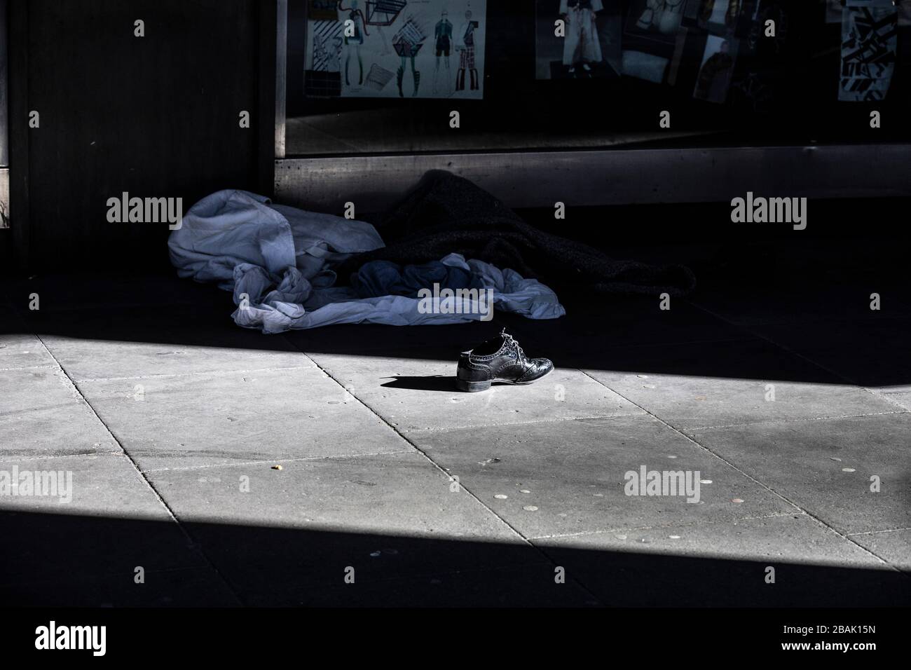 Homeless persons shoe sits abandoned in the sunlight on the street outside Waterloo Station, during the coronavirus lockdown, London, UK Stock Photo
