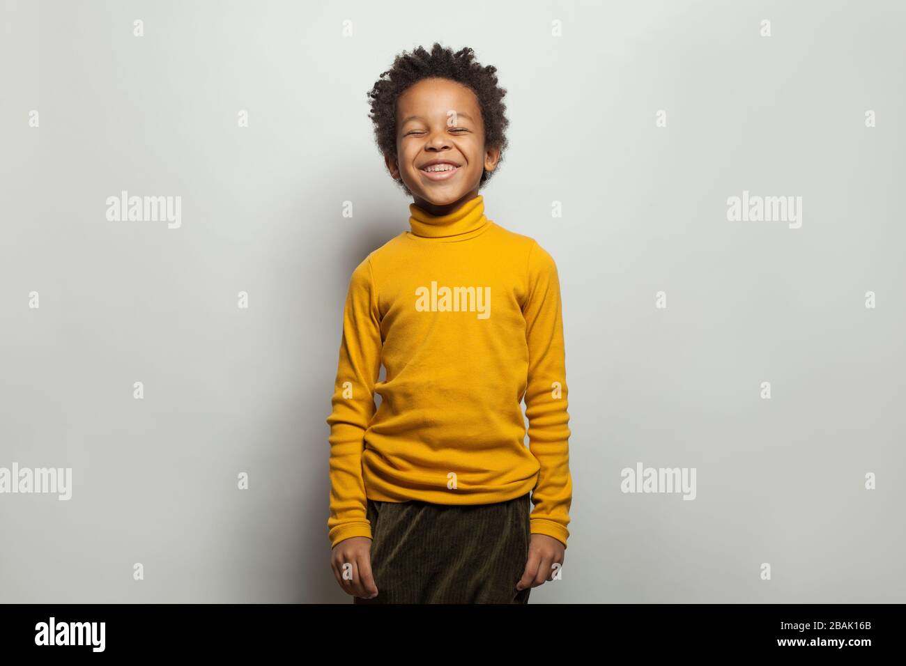 Black kid laughing. Happy little boy on white background Stock Photo