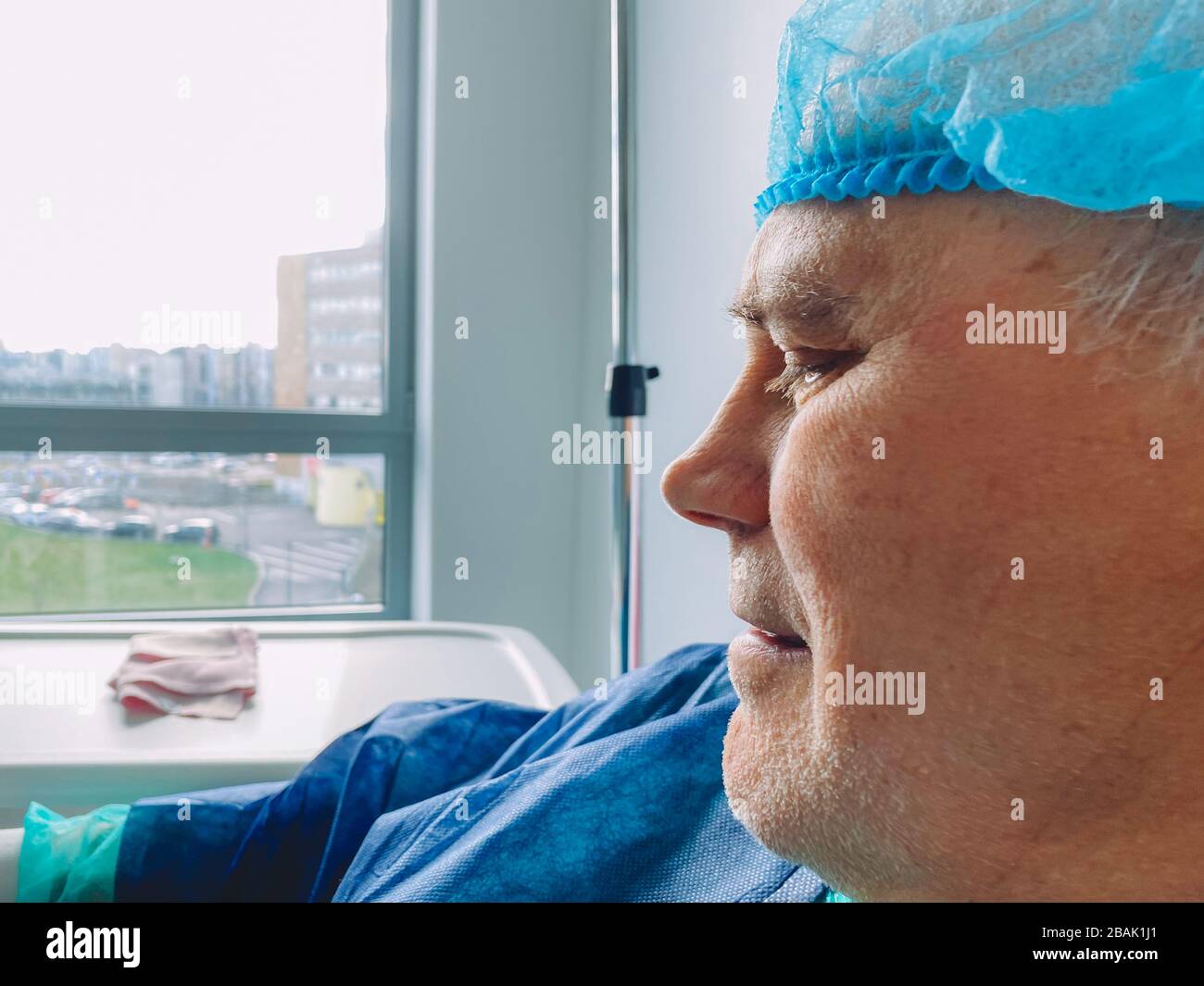 Close-up of senior male face in medical chair inside modern hospital in France resting after infection virus coronavirus optimistic view Stock Photo