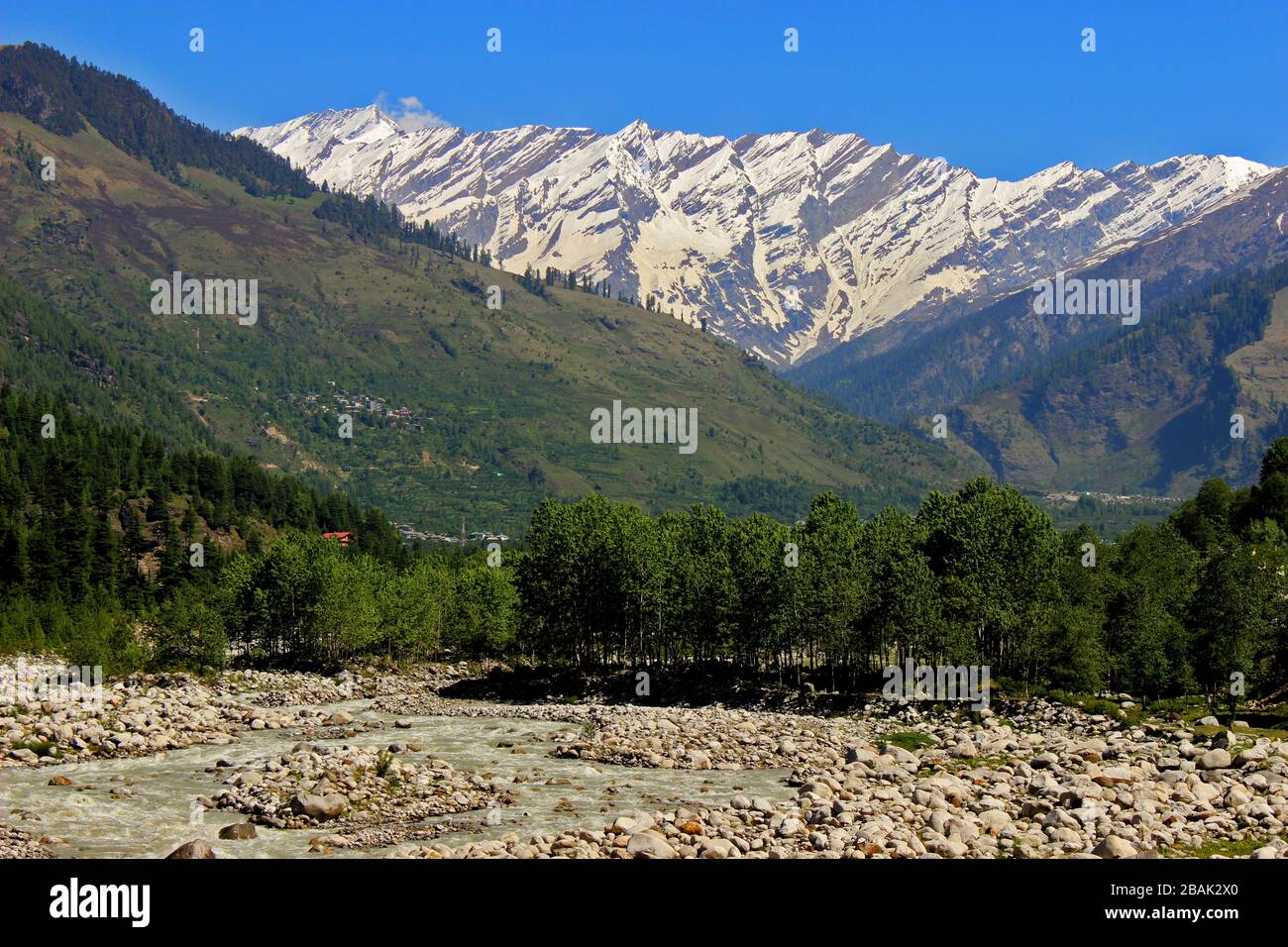 Snow clad himalayas viewed from The Beas River in Manali from Leh - manali highway in summer morning of May, India.Himachal Pradesh Stock Photo