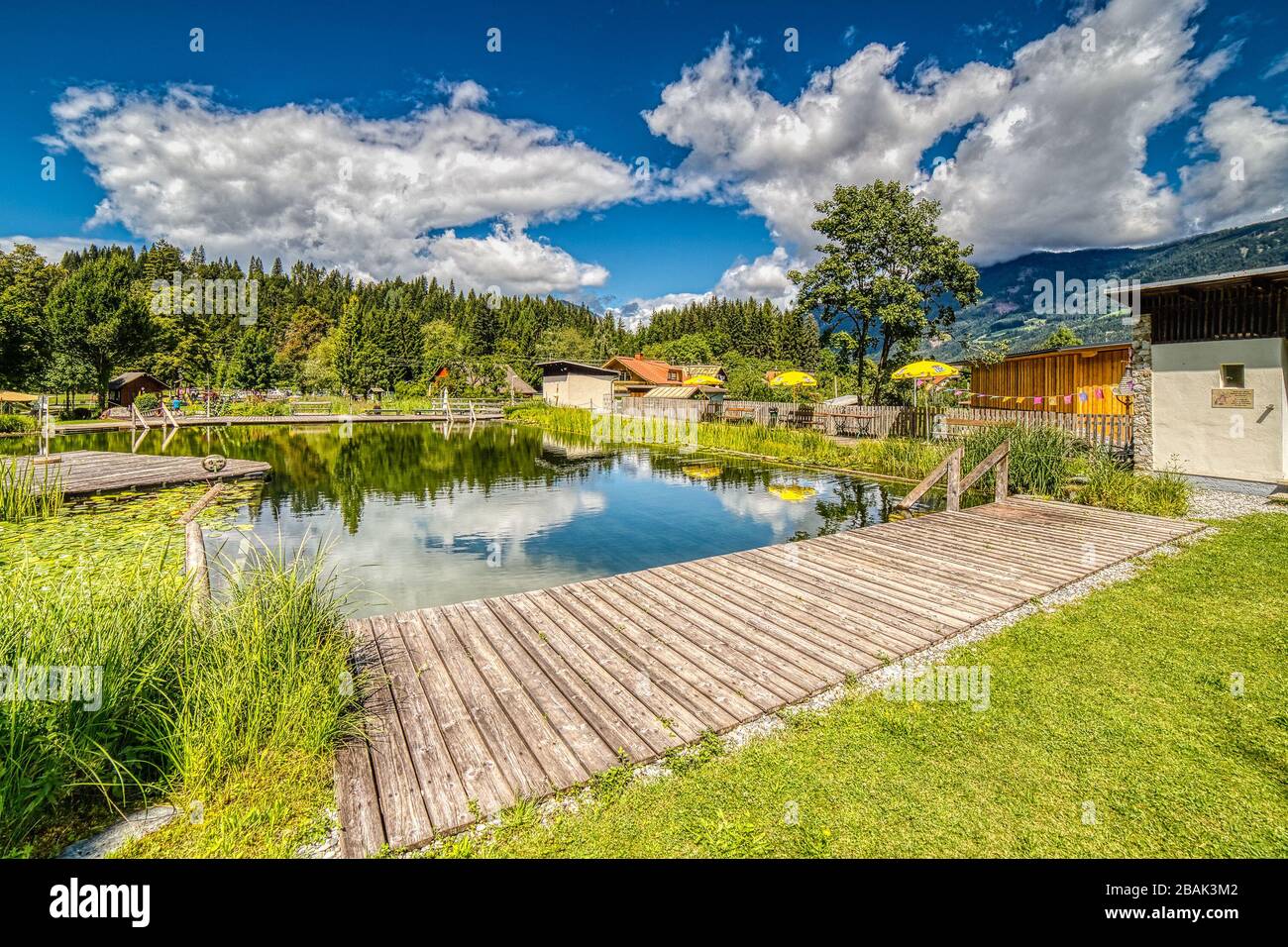 Koetschach-Mauthen (HE), AUSTRIA - AUGUST 14, 2019: the waters of the natural swimming pool are reflecting the clouds that are covering the sky Stock Photo