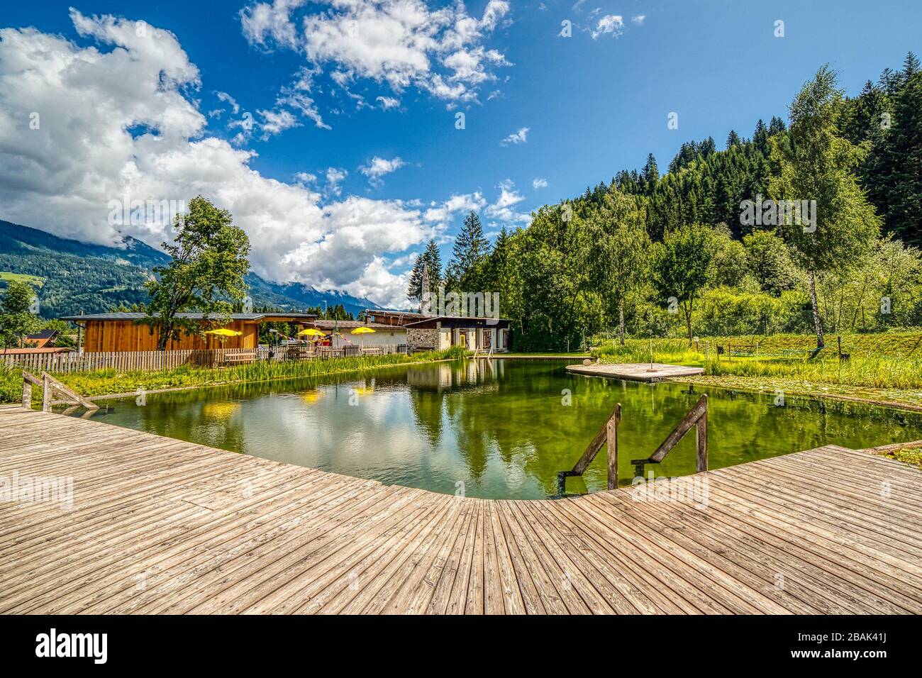 Koetschach-Mauthen (HE), AUSTRIA - AUGUST 14, 2019: the waters of the natural swimming pool are reflecting the clouds that are covering the sky Stock Photo