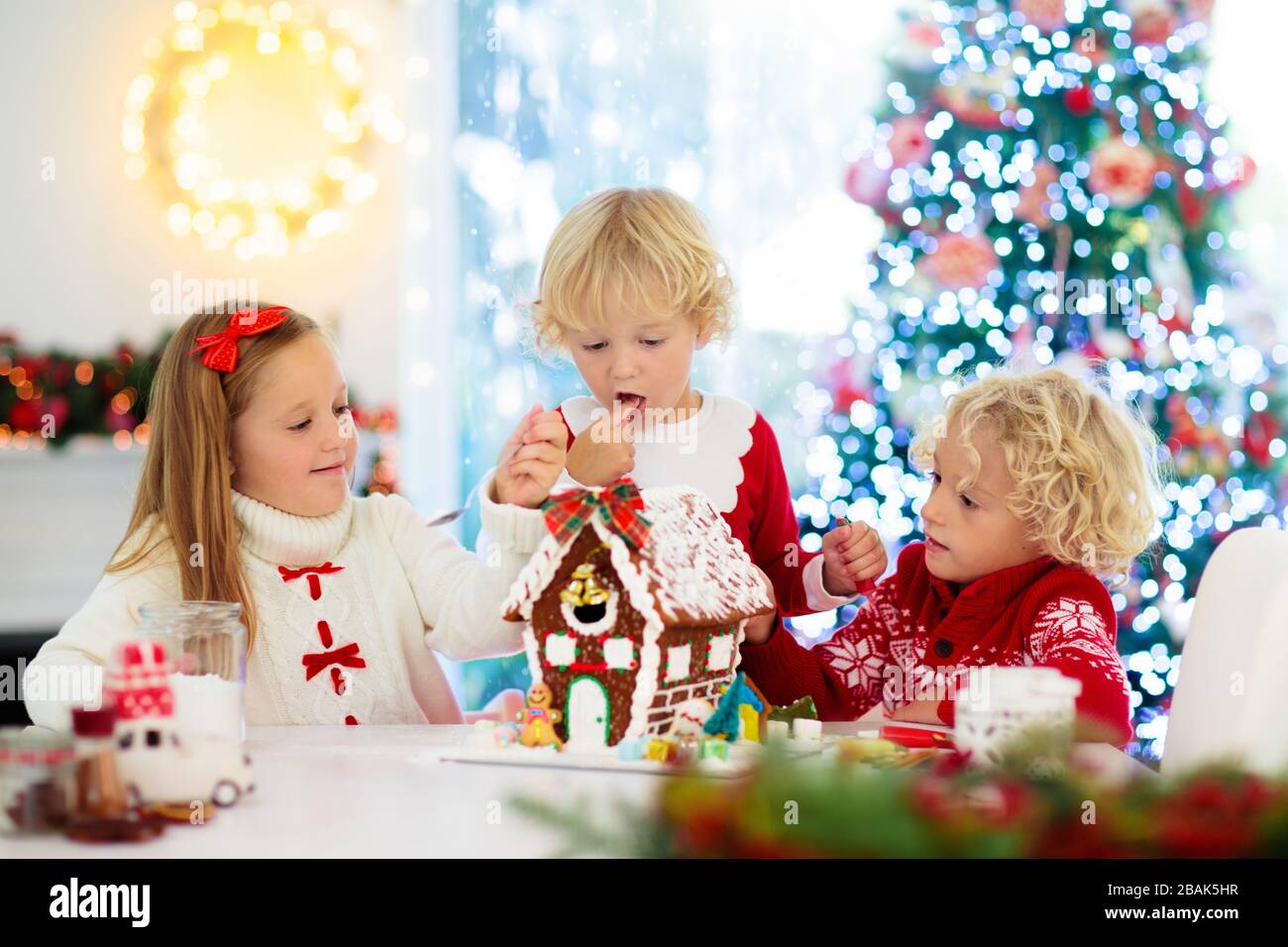 Kids baking Christmas gingerbread house. Children celebrating winter ...