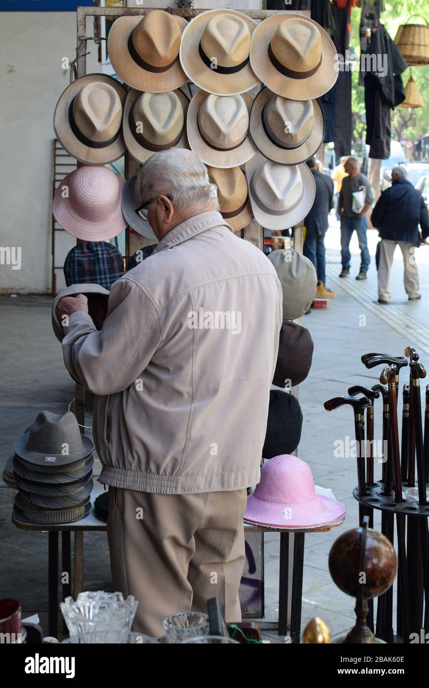 Athens, Greece - October 2, 2018: Man looking at hats for sale in downtown market. Stock Photo