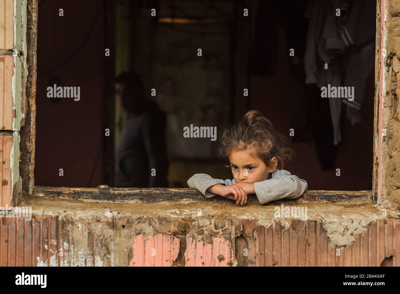 Young, sad gypsy girl alone in a poor gypsy community in rural Hungary. Stock Photo