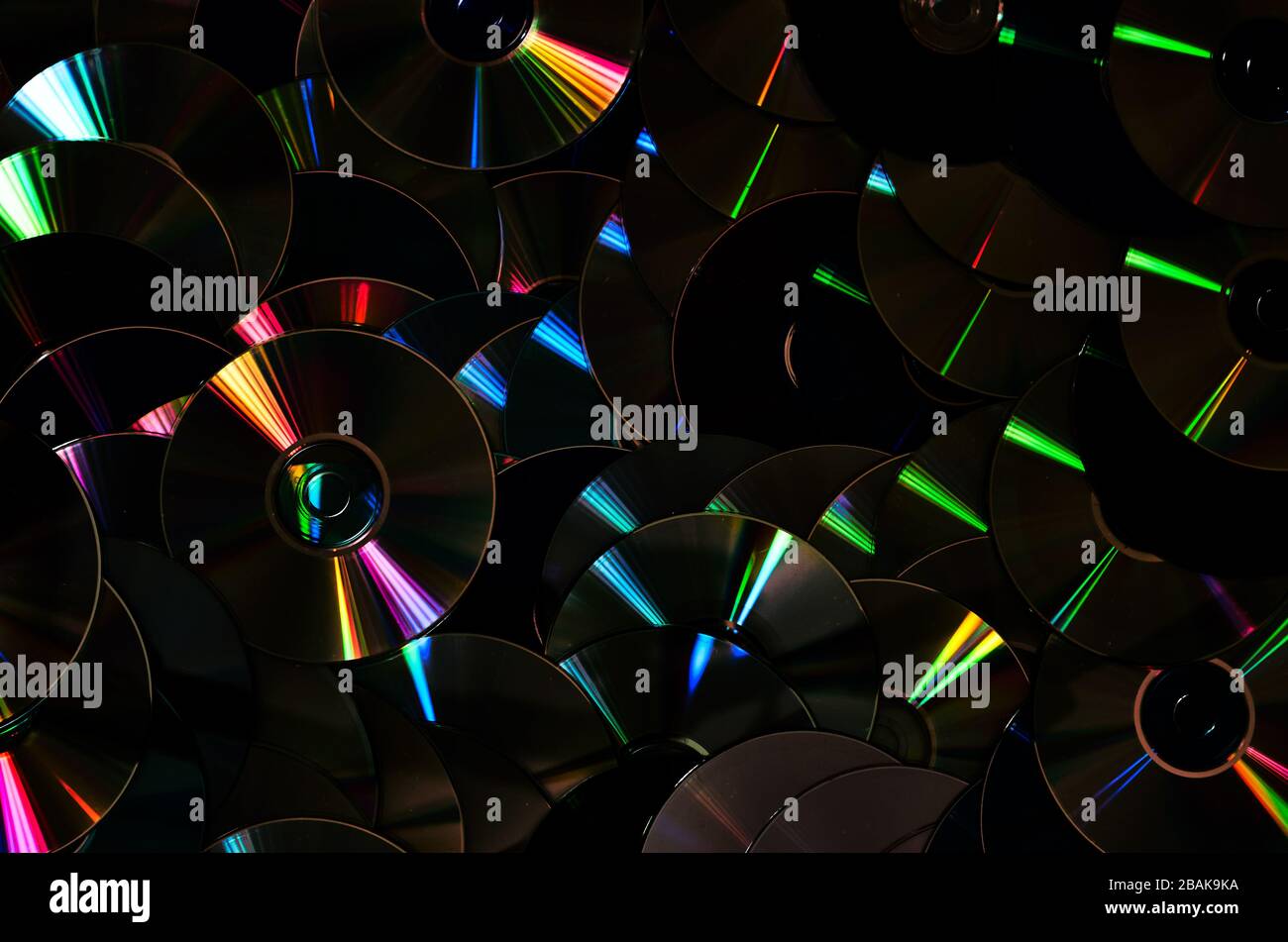 Group of old CD DVD compact optical disk storage medium with dust and scratches. Rainbow spectrum of iridescent colors Stock Photo