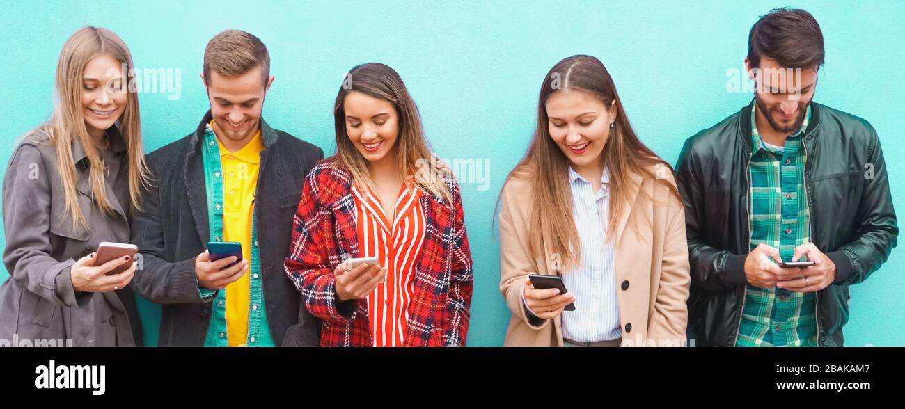 A group of people standing with their smartphones in hand and enjoying ...