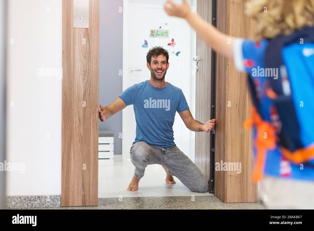 Little boy running towards his father waiting for him at home Stock Photo