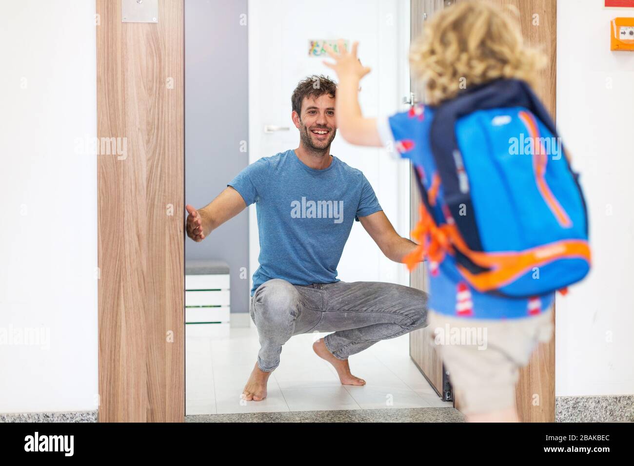 Little boy running towards his father waiting for him at home Stock Photo