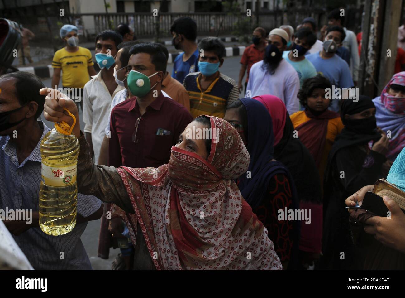 Dhaka, Bangladesh. 28th Mar, 2020. A woman buys soybean oil from a government authorized van a amid COVIC-19 lockdown near the Sadarghat area. Credit: MD Mehedi Hasan/ZUMA Wire/Alamy Live News Stock Photo