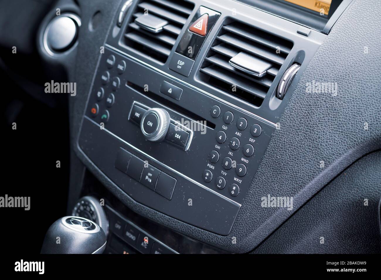 Dark car interior - steering wheel, shift lever and dashboard. Car modern facelift Mercedes E250 model inside view. Front view. Stock Photo