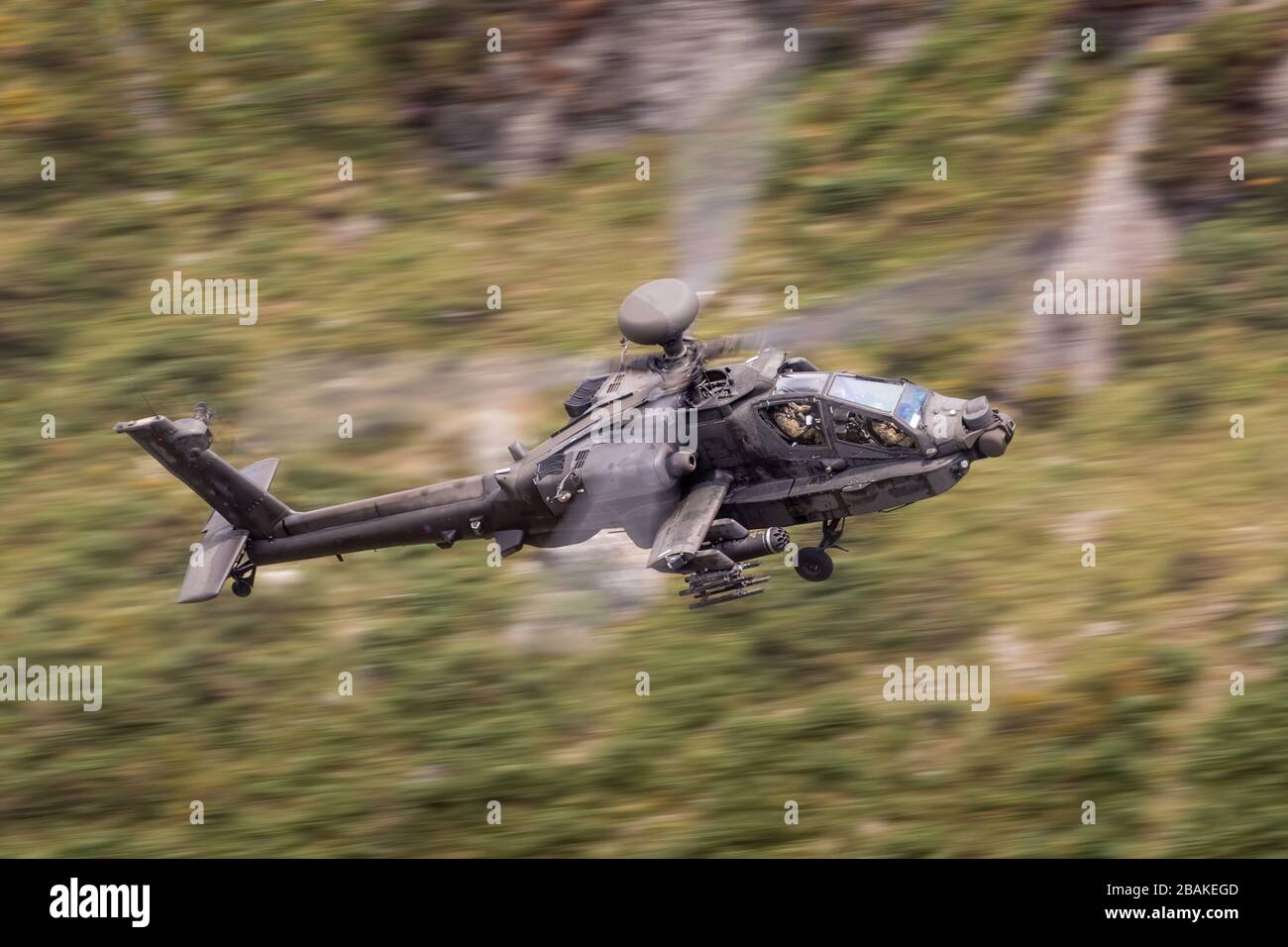United Kingdom Army Air Corps AH-64 Apache attack helicopter flying low level in a Welsh Valley Stock Photo
