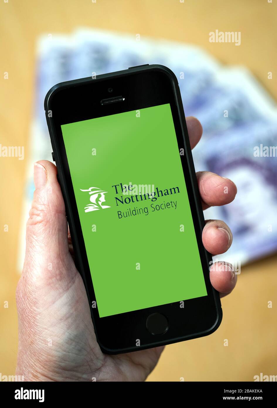 A woman holding a mobile phone showing Nottingham Building Society (editorial use only) Stock Photo