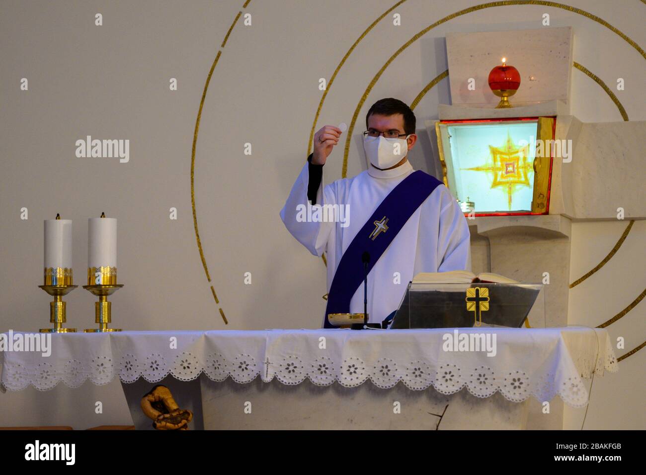 Bratislava, Slovakia. 2019/3/20. A deacon holding the Host before distributing the Eucharist to the faithful in a church during the COVID-19 pandemic. Stock Photo