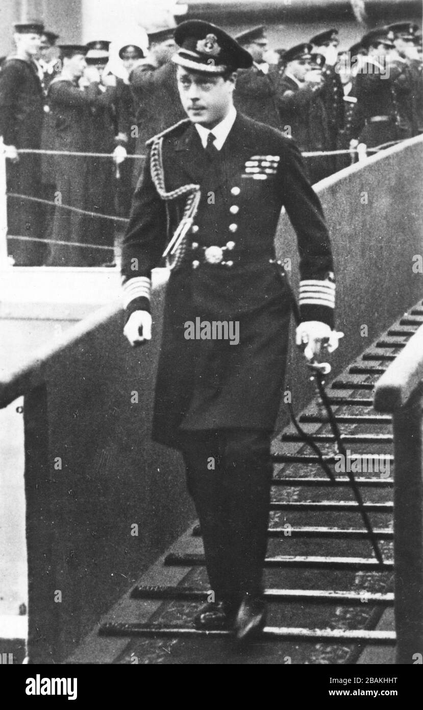 The H.R.H. Prince of Wales (1894-1972) in the late 1930s. He later became King Edward VIII.  Here he is descending a gangway from the British Naval ship H.M.S. Repulse. He is confidently walking down the ramp with his white gloves wrapped around his cane handle.   To see my Royals-related vintage images, Search:  Prestor  vintage  Royal Stock Photo