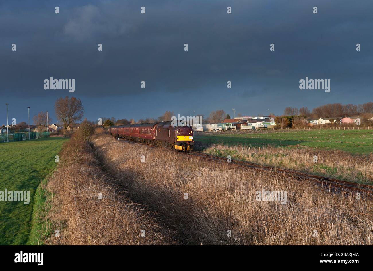 West coast Railways class 37 locomotive 37516 on the single line Heysham branch with a branch line society charter train Stock Photo