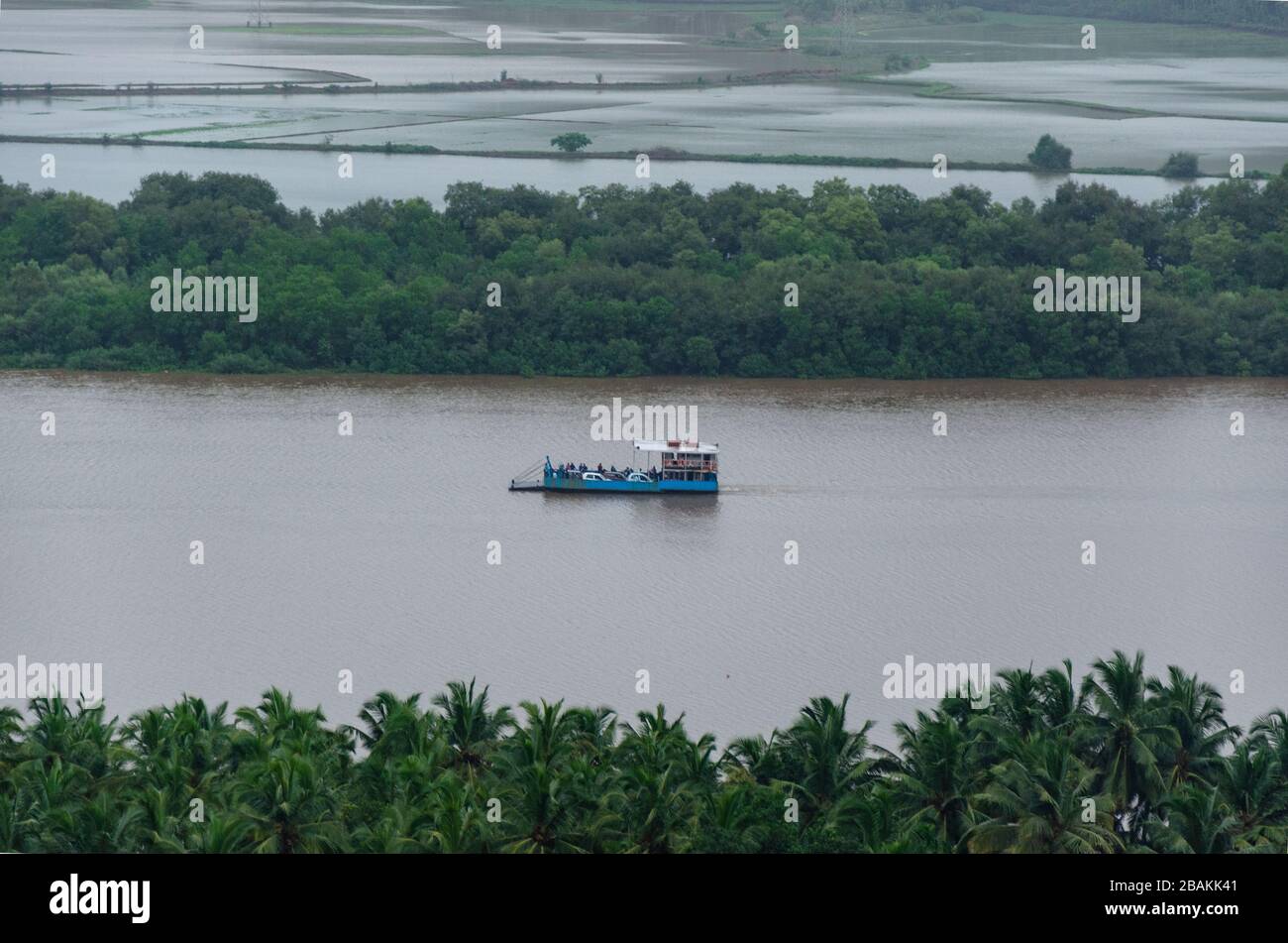 Beautiful view of Durbhat - Rassaim Ferryboat on the Zuari River under dark monsoon clouds as seen from Durbhat Hilltop, Ponda, Goa, India Stock Photo