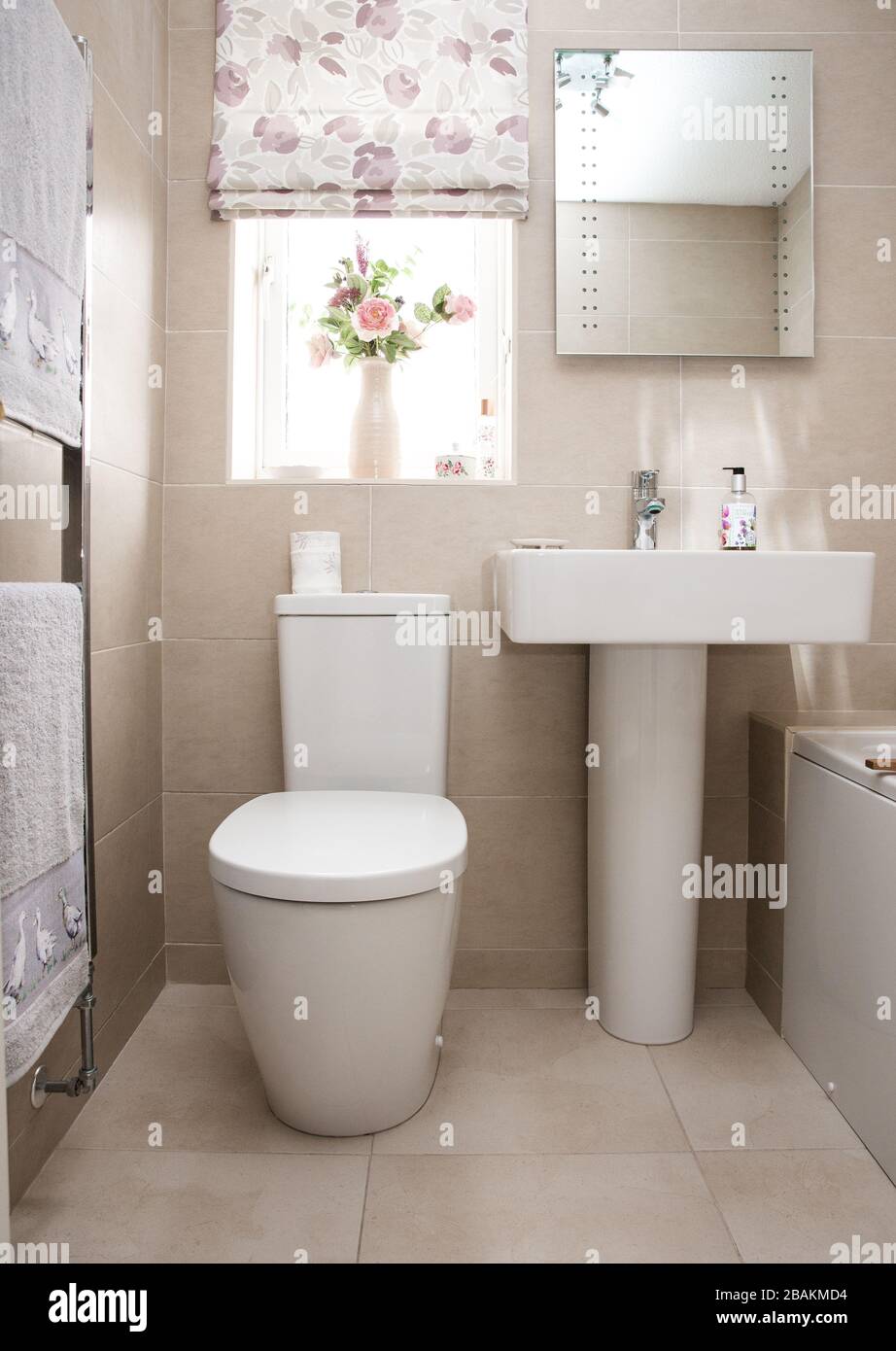 Interior design of contemporary toilet room with round mirror lamp small  black sink white walls with beige small square tiles Stock Photo - Alamy