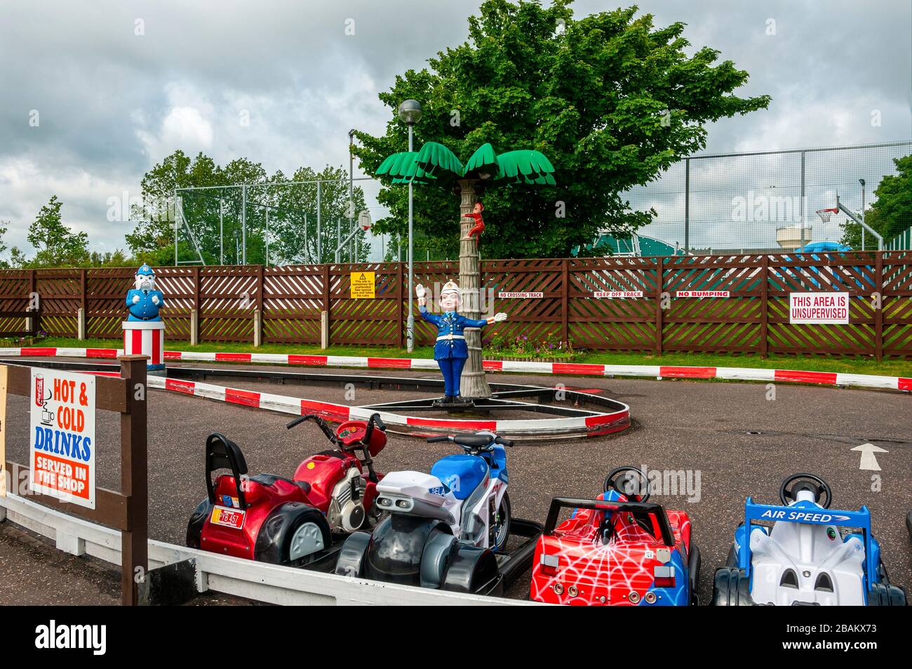 Plastic policemen are located in the centre island of a fun racing circuit for children as small imitation race bikes and cars wait for customers Stock Photo