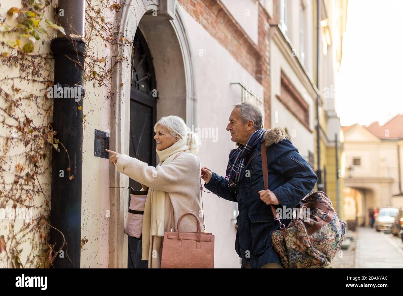 Senior couple ringing the doorbell to their guest house Stock Photo