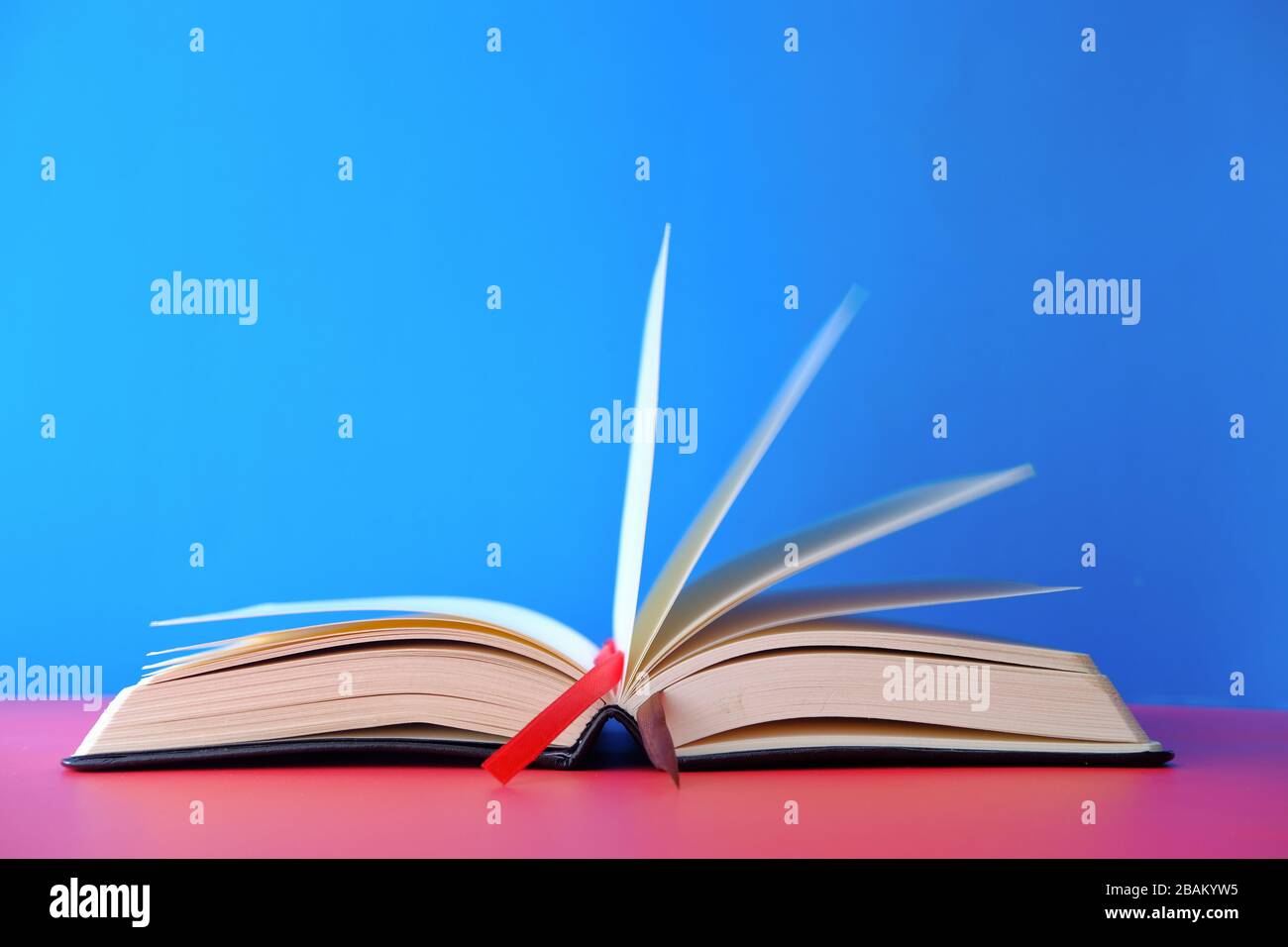 Opened empty book on blue background, space for text. Stock Photo