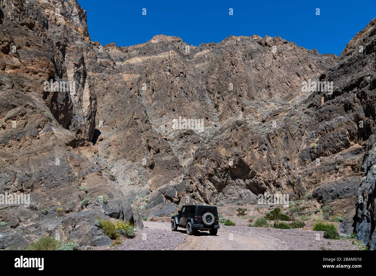 4WD vehicle driving through a rugged desert canyon in Death Valley