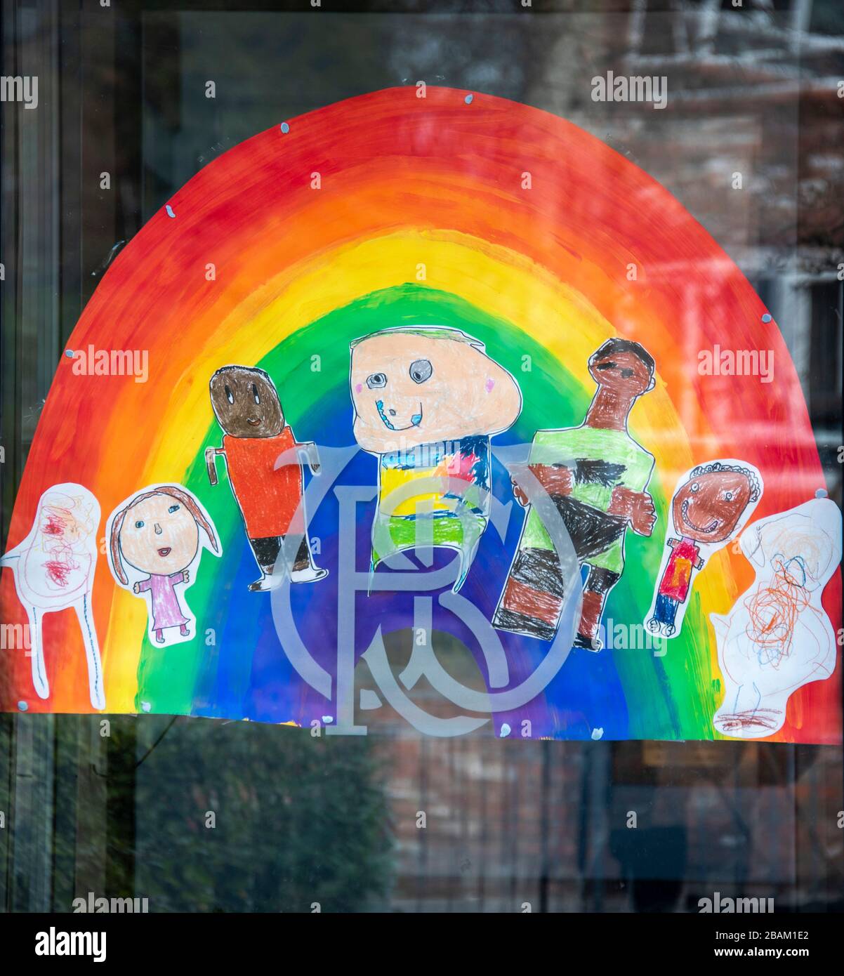 Rainbow designs symbolic of Coronavirus lockdown and stay at home in the UK. This image on the window of a prep school in Wilmslow, Cheshire, UK 28.03 Stock Photo